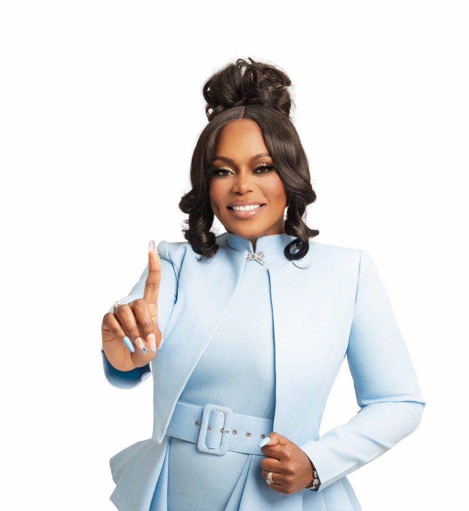 Zorisha Hackett in a baby blue jacket with a commanding gesture